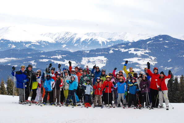 Bild zeigt Gruppenfoto der Semester-Ski Freizeit vor weißen Bergen.
